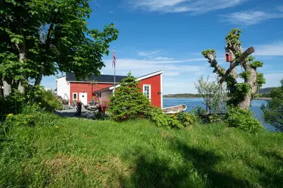 a house on the shore of a body of water at Eget hus i sjøkanten ved fjorden in Langevåg
