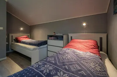 two beds in a small room with two beds at Eget hus i sjøkanten ved fjorden in Langevåg