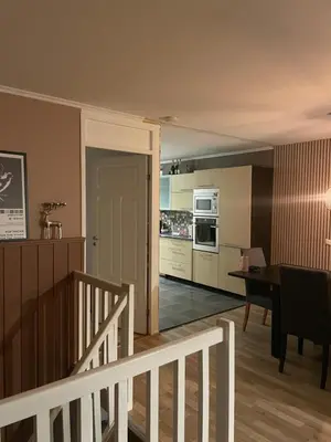 a kitchen and dining room with a table and a stairway at 2 etasjers leilighet in Trondheim