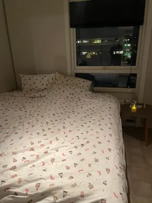 a bed in a bedroom with a window at 2 etasjers leilighet in Trondheim