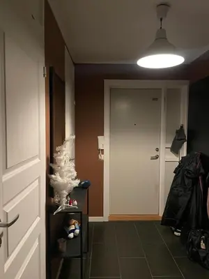 a hallway with a door and a christmas tree at 2 etasjers leilighet in Trondheim