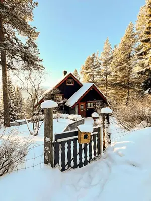 a house covered in snow in front of a fence at TheHideaway in Sel