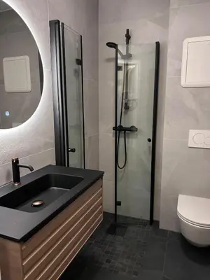 a bathroom with a shower and a black sink at 2 bed apartment in Trondheim