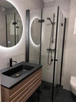 a bathroom with a black sink and a shower at 2 bed apartment in Trondheim