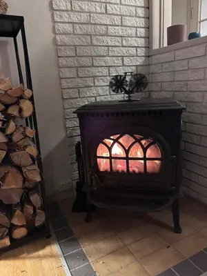 a black stove with a fire inside of it at 2 bed apartment in Trondheim