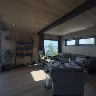 a living room with a couch and a chair at Large modern cabin with a spectacular view! in Grønningen