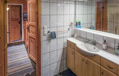 a bathroom with a sink and a mirror at Beach Front Home In Omastrand in Gjuvsland
