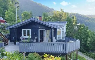 a small cabin with a porch and a deck at Beach Front Home In Omastrand in Gjuvsland