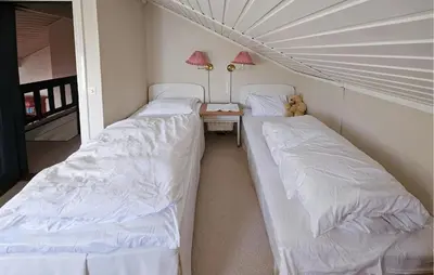two beds in a room with a table and a teddy bear at 4 Bedroom Beautiful Home In Hemsedal in Hemsedal