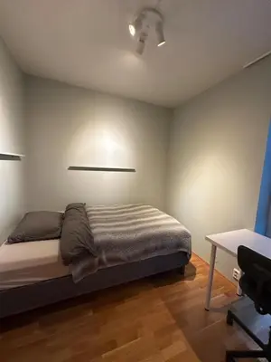 a bedroom with a bed and a desk in it at Spacious apartment with a great view and parking in Trondheim