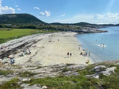 a group of people on a beach near the water at Great cottage with unique views and high standard in Tørhogg