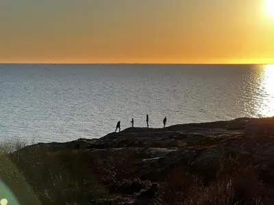 a group of people standing on a rock near the water at Great cottage with unique views and high standard in Tørhogg