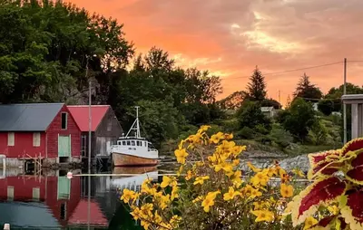 a boat in the water next to a red house at Stunning Home In Torangsvåg in Skår