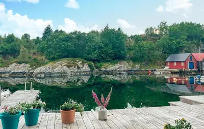 a body of water with a red house and plants at Stunning Home In Torangsvåg in Skår