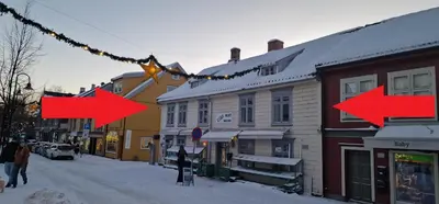 a city street with red arrows on a string at Storgata 36 in Lillehammer