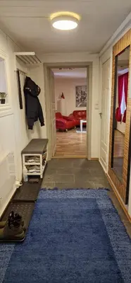 a hallway with a living room with a red couch at Storgata 36 in Lillehammer