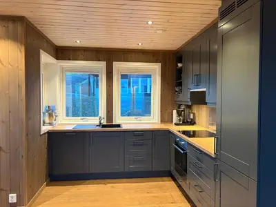 a kitchen with gray cabinets and windows and a counter at Stor leilighet på Bualie, Golsfjellet in Gol