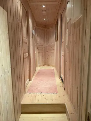 a hallway with wooden walls and a rug in a room at Cabin at Kvamskogen with a great view in Kvam