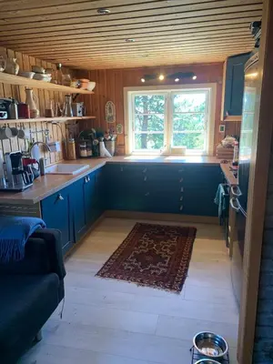 a kitchen with blue cabinets and a window at Cabin at Kvamskogen with a great view in Kvam