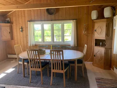 a kitchen with a table and chairs and a window at Cabin at Kvamskogen with a great view in Kvam