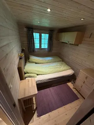 a small room with a bed in a tiny house at Cabin at Kvamskogen with a great view in Kvam