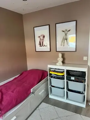 a bedroom with a pink bed and two pictures on the wall at Villa til leie under SKI-VM in Trondheim