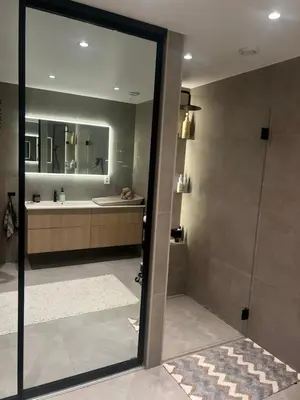 a bathroom with a shower and a sink and a mirror at Villa til leie under SKI-VM in Trondheim