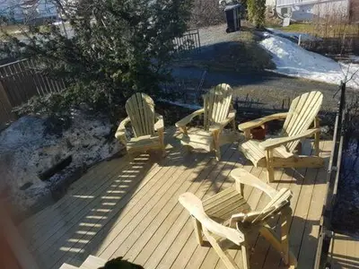 three rocking chairs sitting on a wooden deck at Trondhjemsvegen in Gjøvik