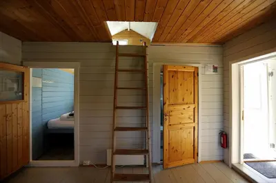 a room with a ladder and a room with a bed at Cabin 