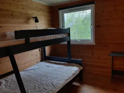 a bunk bed in a log cabin with a window at Cabin 