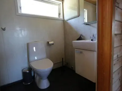 a bathroom with a toilet and a sink and a window at Cabin 
