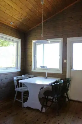 a room with a sink and chairs and two windows at Cabin 