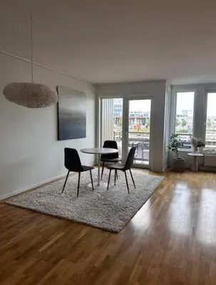 a living room with a table and chairs at Apartment in city centre with view of the canal in Trondheim