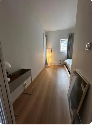 an empty room with a bed and a television at Apartment in city centre with view of the canal in Trondheim