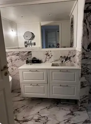 a white bathroom with a sink and a mirror at Apartment in city centre with view of the canal in Trondheim
