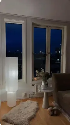 a living room with two windows and a couch at Apartment in city centre with view of the canal in Trondheim
