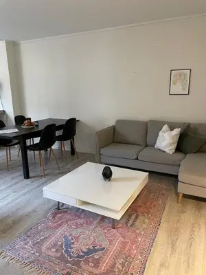 a living room with a couch and a table at Bright Modern Apartment - Prime Location in Ålesund