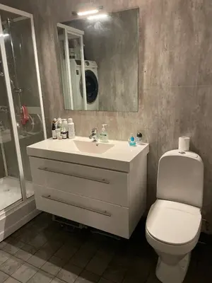 a bathroom with a sink and a toilet and a mirror at Bright Modern Apartment - Prime Location in Ålesund