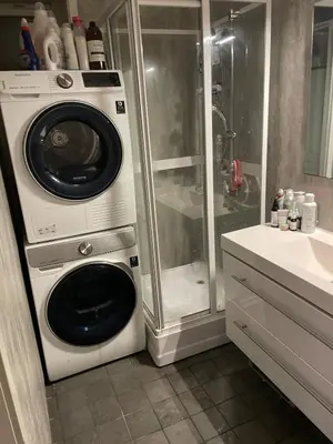 a washing machine in a bathroom with a shower at Bright Modern Apartment - Prime Location in Ålesund