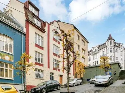 a building with cars parked in a parking lot at Bright Modern Apartment - Prime Location in Ålesund