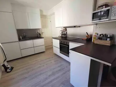 a kitchen with white cabinets and a black counter top at Bright Modern Apartment - Prime Location in Ålesund