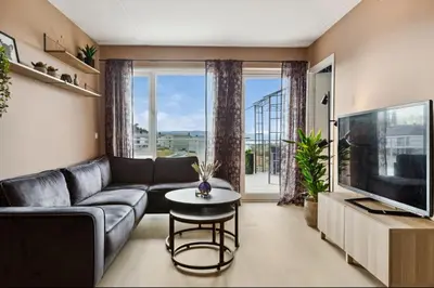 a living room with a couch and a tv at Fin leilighet for VM in Trondheim