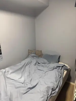 an unmade bed in a white room at Fin leilighet for Ski VM in Trondheim