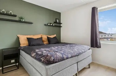 a bed in a room with a window at Fin leilighet for Ski VM in Trondheim