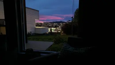 a room with a window with a view of a city at Modern apartment with stunning view over city in Trondheim