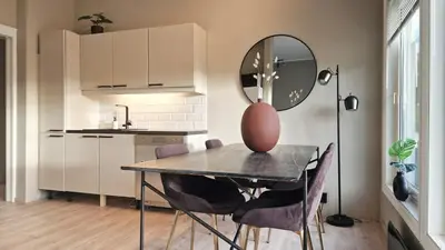 a kitchen with a table with chairs and a mirror at Modern apartment with stunning view over city in Trondheim