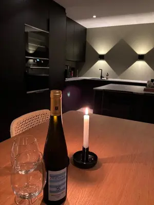 a bottle of wine and a candle on a table at Beautiful house - walking distance of everything in Trondheim
