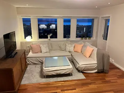 a living room with a couch and a table at Unique City Center 3-rooms panoramic view with free parking in Trondheim