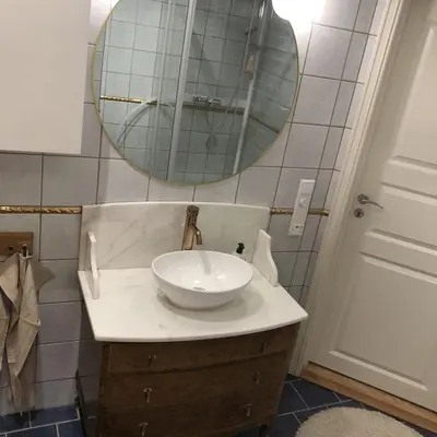 a bathroom with a white sink and a mirror at Unique City Center 3-rooms panoramic view with free parking in Trondheim