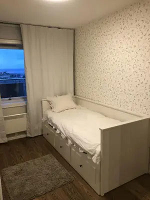 a white bed in a room with a window at Unique City Center 3-rooms panoramic view with free parking in Trondheim